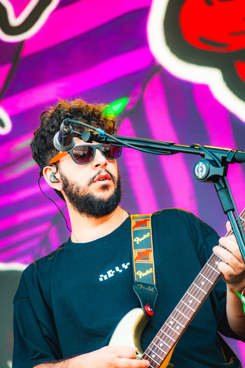 Banda tocando ao vivo com luzes coloridas e público ao fundo