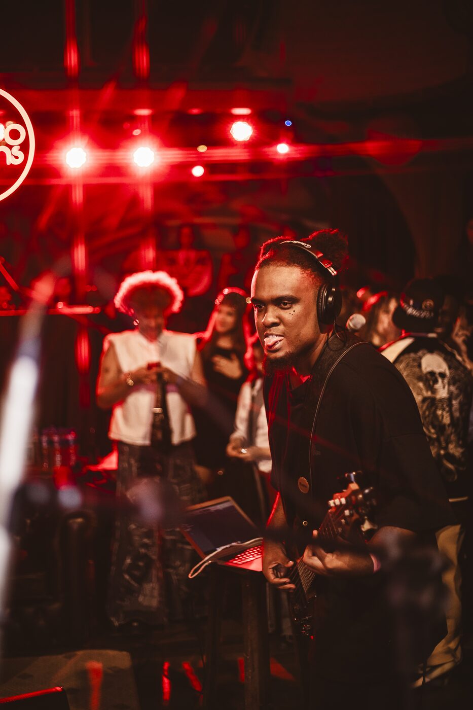 Músico tocando guitarra em apresentação com luzes quentes de palco